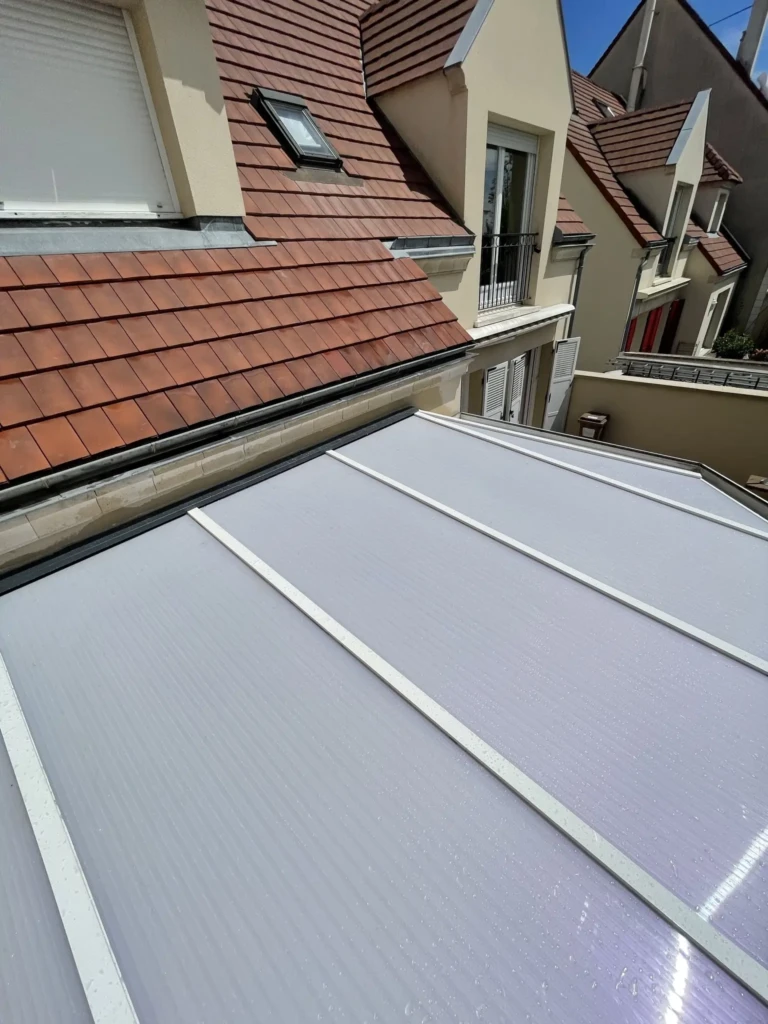 Ancienne toiture de véranda avec des joints noirs usés à Carrières-sur-Seine.